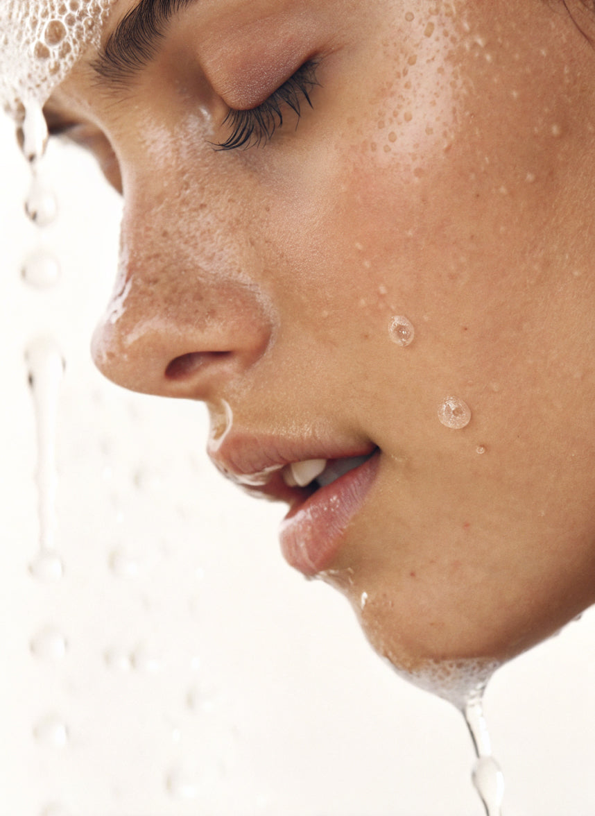 Close-up of a woman washing her face with Purabeauti Primo Cleanser
